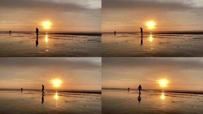日落时海滩上的剪影。