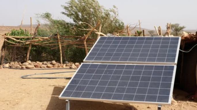摩洛哥Erg Chigaga撒哈拉沙漠中的太阳能电池板。太阳能从水井为游牧民族的小菜园取水。