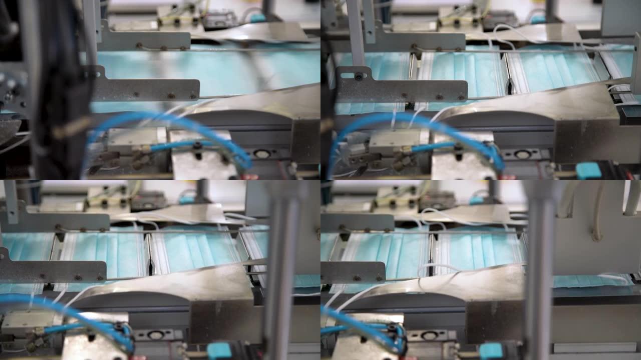 工厂生产医用口罩的特写过程。大量制造呼吸医用口罩的自动化机械。