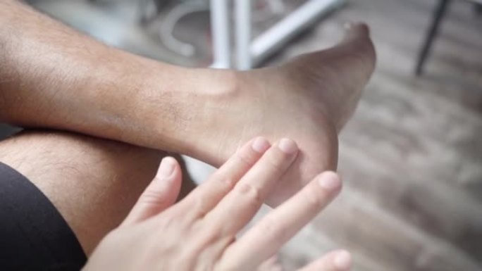 男性使用按摩丸脚踝按摩来缓解疼痛。