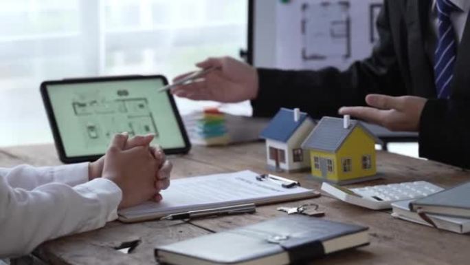 房屋模型与代理商和客户讨论购买，获得保险或贷款房地产或财产的合同。