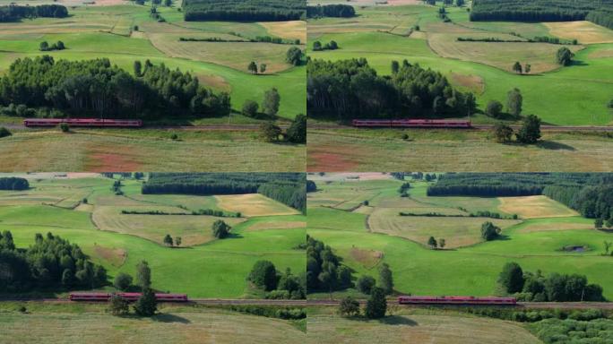 波兰公共交通基础设施的旅客列车鸟瞰图景观。客运电动火车穿过美丽的欧洲乡村的农田。铁路上的红色火车。