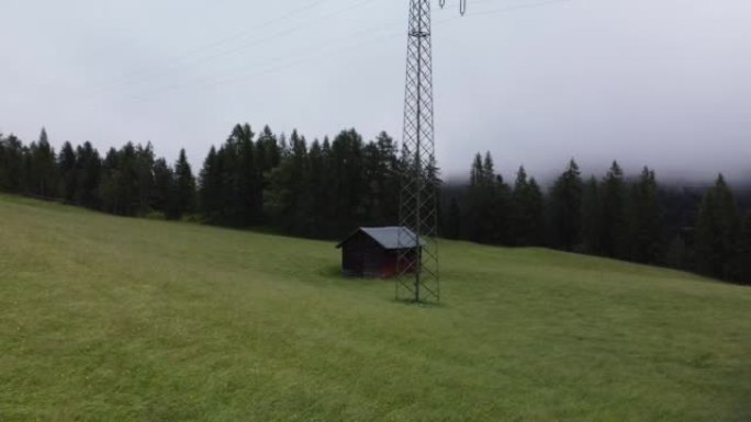奥地利Reith bei Seefeld绿草上的小屋，雾天有林木