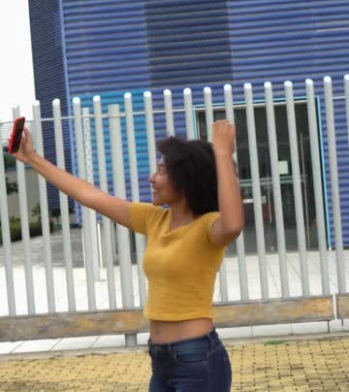 女人在公园跳舞时用手机拍摄自己