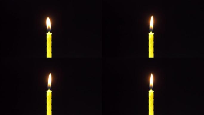 带阿尔法通道的蜡烛火焰。蜡烛燃烧着柔和的黄色火焰。烛光下，孤立。特写，慢动作。蜡烛在黑色背景上燃烧。