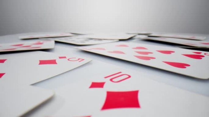 在白色的酒神地上玩牌。极其特写详细，随机躺着红心钻石套装的扑克牌。