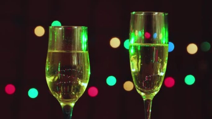 两杯香槟在多色花环的背景上。