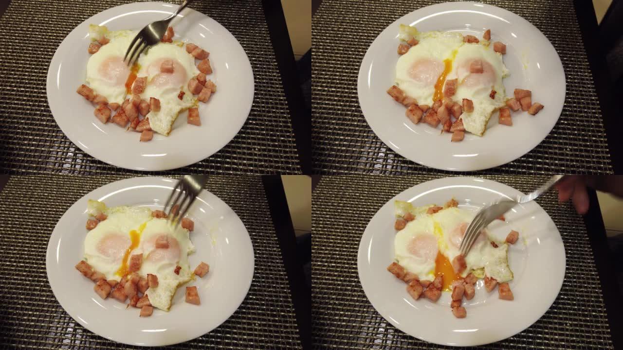 进食过程。这个人正在吃早餐，这个人坐在桌旁吃煎蛋。早上在酒店餐厅，观景点。