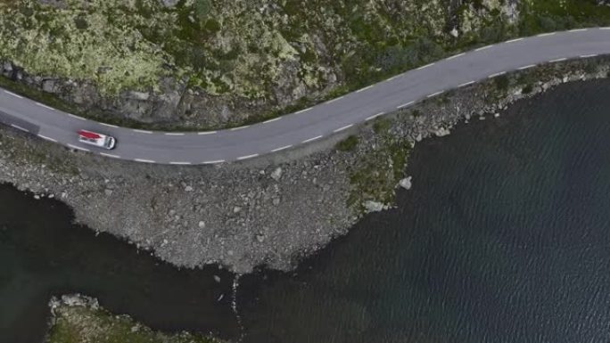 穿过挪威高地的公路上有红船的露营车的风景鸟瞰图