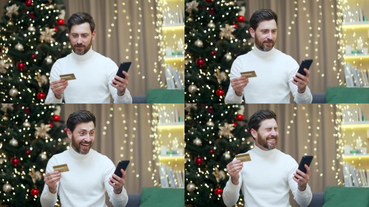 快乐男人在新年圣诞节假期在家中使用手机和信用银行卡在线购物
