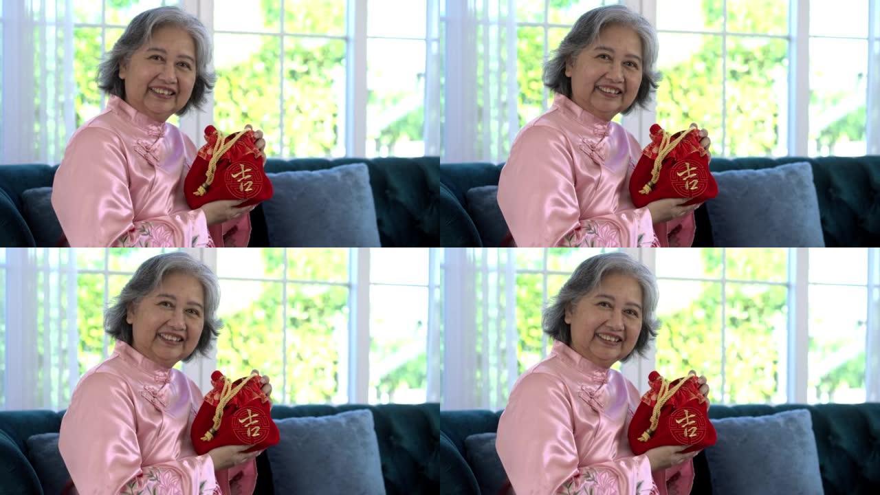 亚洲高级妇女在农历新年展示幸运的红色包