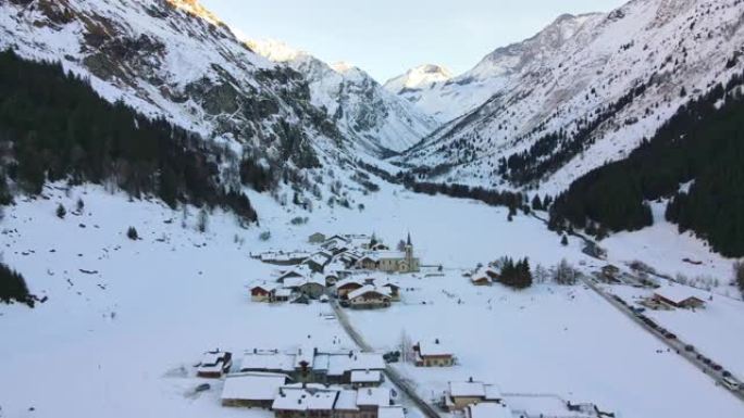 令人惊叹的鸟瞰图的瑞士小村庄位于两个被雪覆盖的高岩山脚下，瑞士滑雪胜地小镇的冬季全景，传统的小屋，酒