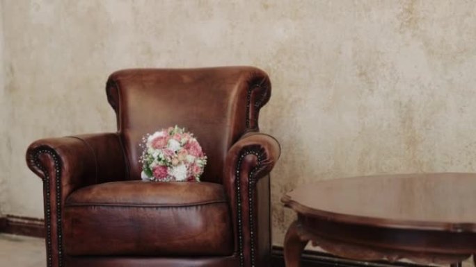 棕色豪华皮革扶手椅上新娘花束的特写镜头