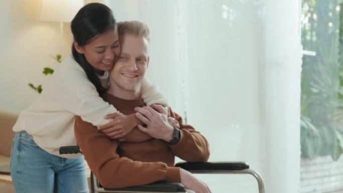 亚洲女孩从后面拥抱她的轮椅男友