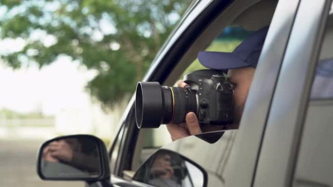 私人侦探坐在车内用专业单反相机拍照