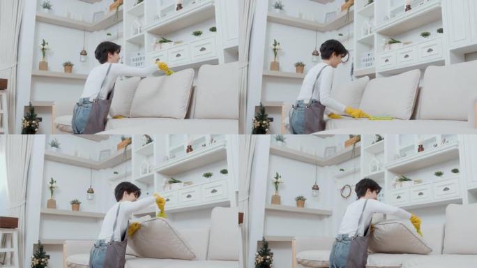 快乐的亚洲年轻女子扫沙发和家具打扫房子