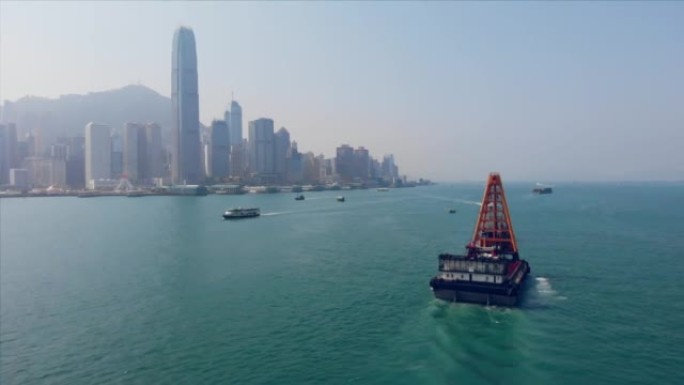 一艘工业船在香港城市的水和城市摩天大楼中的空中拍摄