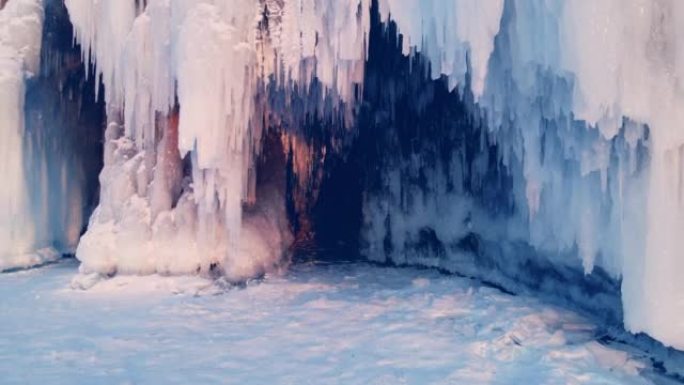 日落时分，在冬季贝加尔湖上带冰和冰柱的海角。