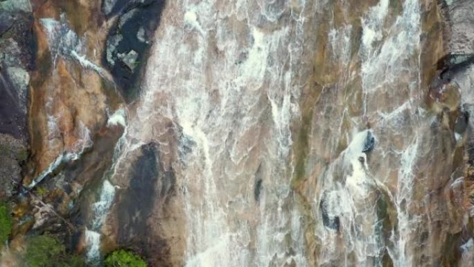 新鲜的山瀑布从岩石上冲下的空中透视