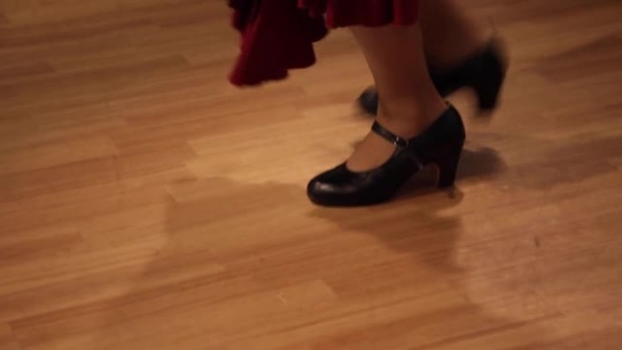 一个穿着红色长裙和黑色高跟鞋的舞者的特写镜头