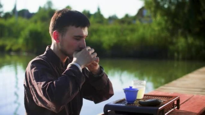 男子在湖边码头放松时喝中国茶