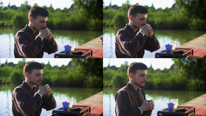 男子在湖边码头放松时喝中国茶