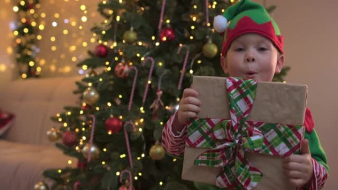 小精灵儿童男孩躲在大礼品盒后的脸绿丝带蝴蝶结圣诞节