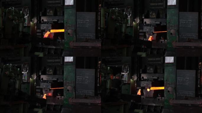 铁匠工厂。用工业锻压机锻造大型热金属坯。金属锻造厂的技术设备。大型机器，铁匠移动并加热金属，并为轨道