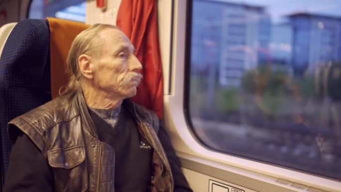 戴眼镜的老人坐火车旅行，早上看着窗外