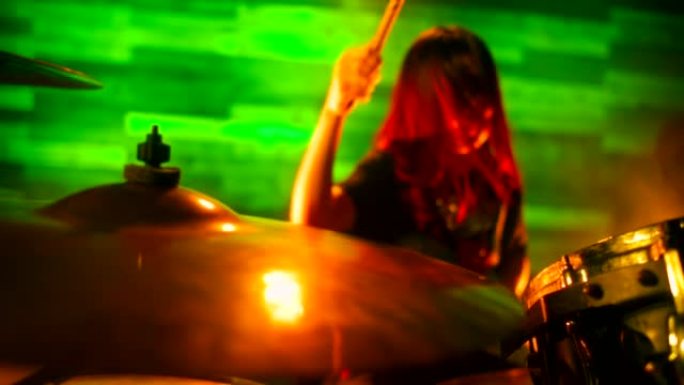 红发鼓手女孩在慢动作中快速演奏鼓套件。