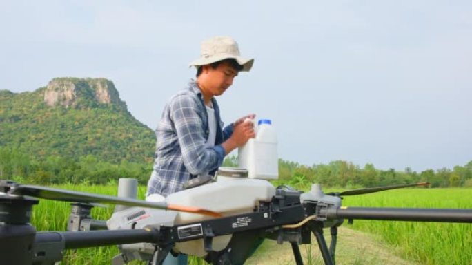 工程师正在检查农业无人机，因为它们在喷洒药物或肥料的稻田上空飞行。