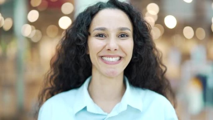 一个快乐的西班牙裔女人笑脸的特写肖像年轻卷发漂亮的黑发女性看着相机，在模糊的背景上微笑bokeh l