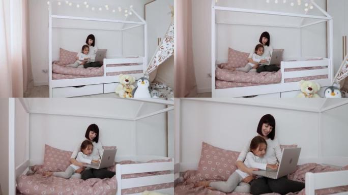 快乐可爱的女儿和年轻的母亲与父亲或祖母使用笔记本电脑进行在线视频通话