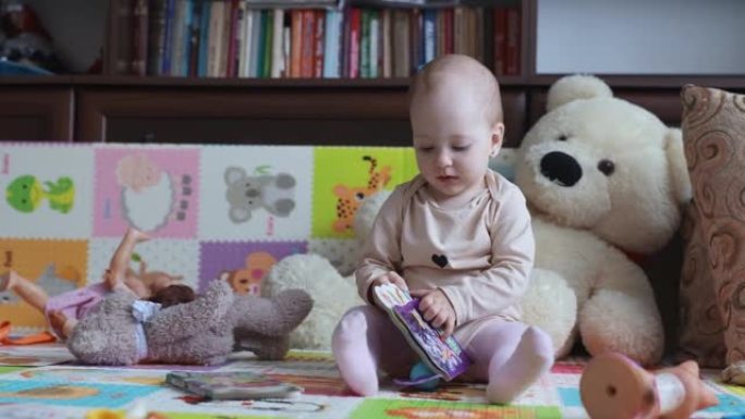 婴儿正在客厅里玩一本儿童读物。