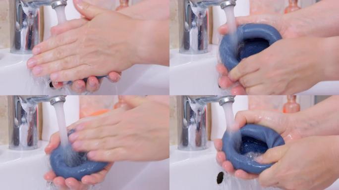 人在水槽里用肥皂在水流下洗耳垫苹果AirPods Max