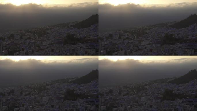 摩洛哥切夫沙万的日落高角度拍摄，在城市的山丘和建筑物后面