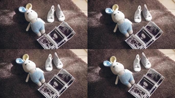 超声波扫描婴儿照片，针织兔子玩具和婴儿鞋在阳光下的地板上，父母在家准备分娩，享受孕妇的假期。产妇和怀