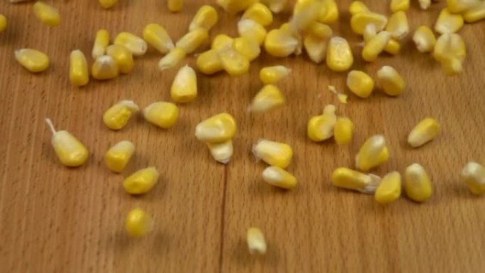 黄色的玉米粒掉在木板上，慢动作