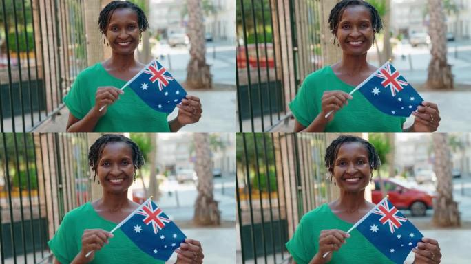 中年非洲裔美国妇女微笑着自信地在街上举着澳大利亚国旗