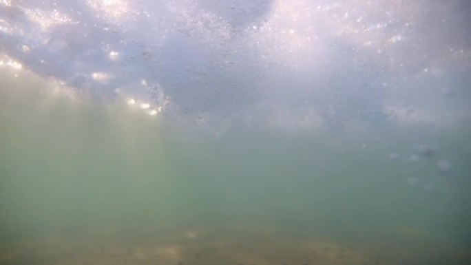 带有太阳光线的海底穿透了水面。水面上方耀眼的太阳。阳光下闪烁的水泡。专注于泡沫。完美的背景。版本3