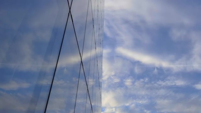 位于首都中心的高大玻璃建筑。美丽的云彩映照在摩天大楼的窗户上。日落时的商业区