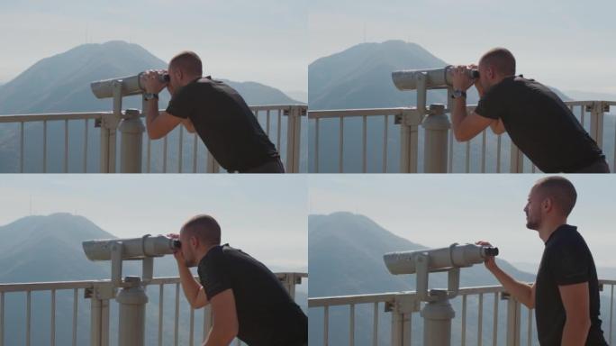 年轻人游客通过投币式双筒望远镜观察自然。