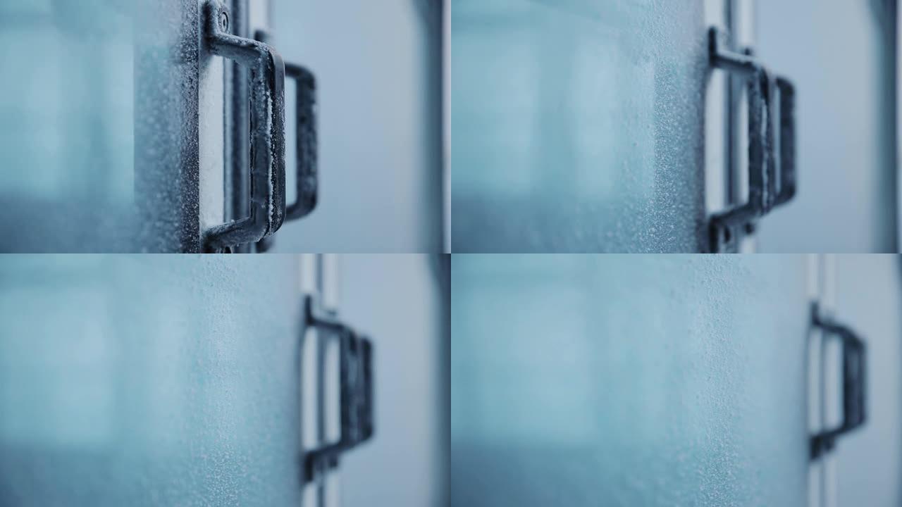 门把手上覆盖着霜。覆盖白霜的玻璃现代房屋门。瑞士阿尔卑斯山