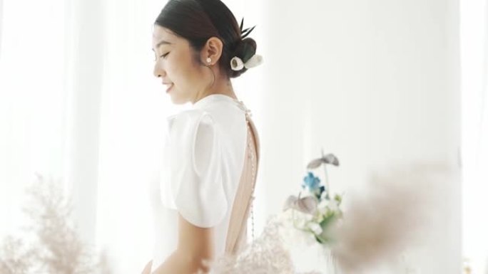 年轻的东亚新娘，身穿白色礼服，正在拍摄婚纱照