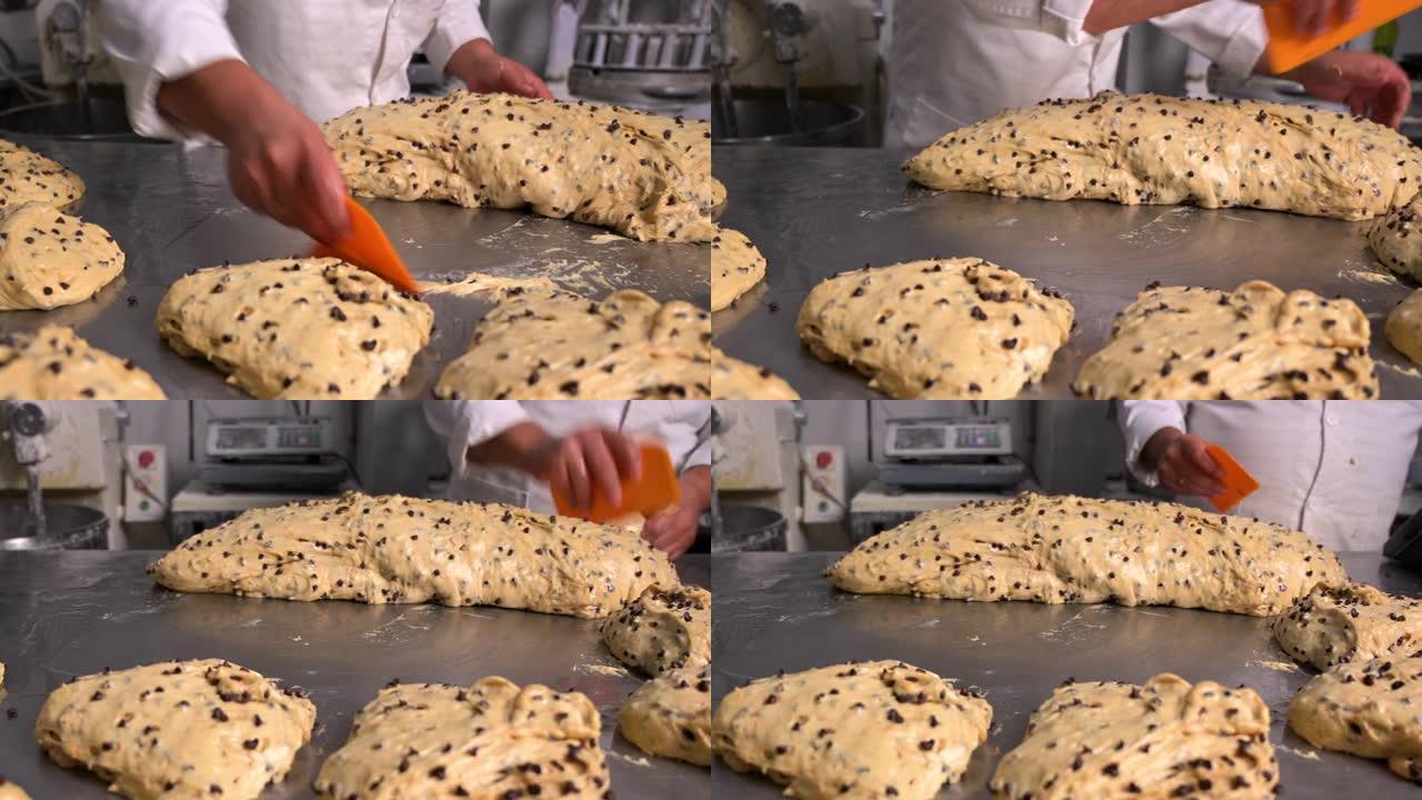 糕点厨师切块面团，用于生产工匠panettone。高质量4k镜头
