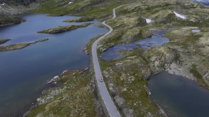 穿过挪威高地的公路上有红船的露营车的风景鸟瞰图