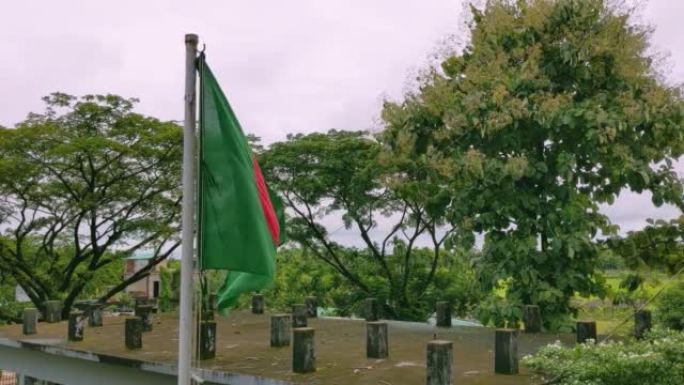 孟加拉国的官方国旗飘扬在学校操场上。多云的天空中悬挂着孟加拉国国旗。