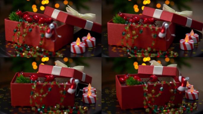 带有圣诞装饰品礼物的红色打开盒的特写在托盘上旋转