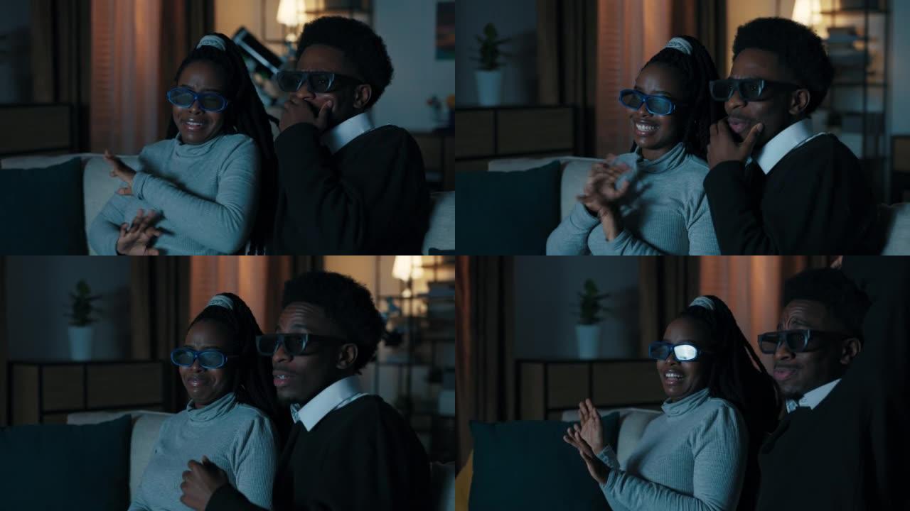 两个非洲外表的学生坐在沙发上看电影。他们戴上3D眼镜。这部电影的情节既有趣又出乎意料。年轻人情感讨论