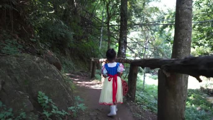 阳光明媚的夏日，一个穿着公主服装的孩子在树林里徒步旅行